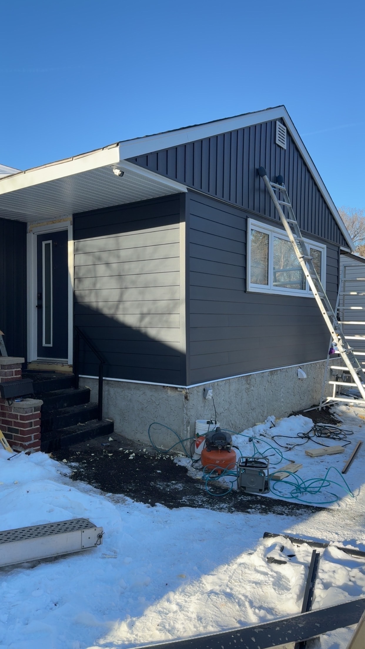 Dark charcoal siding installation in progress Regina