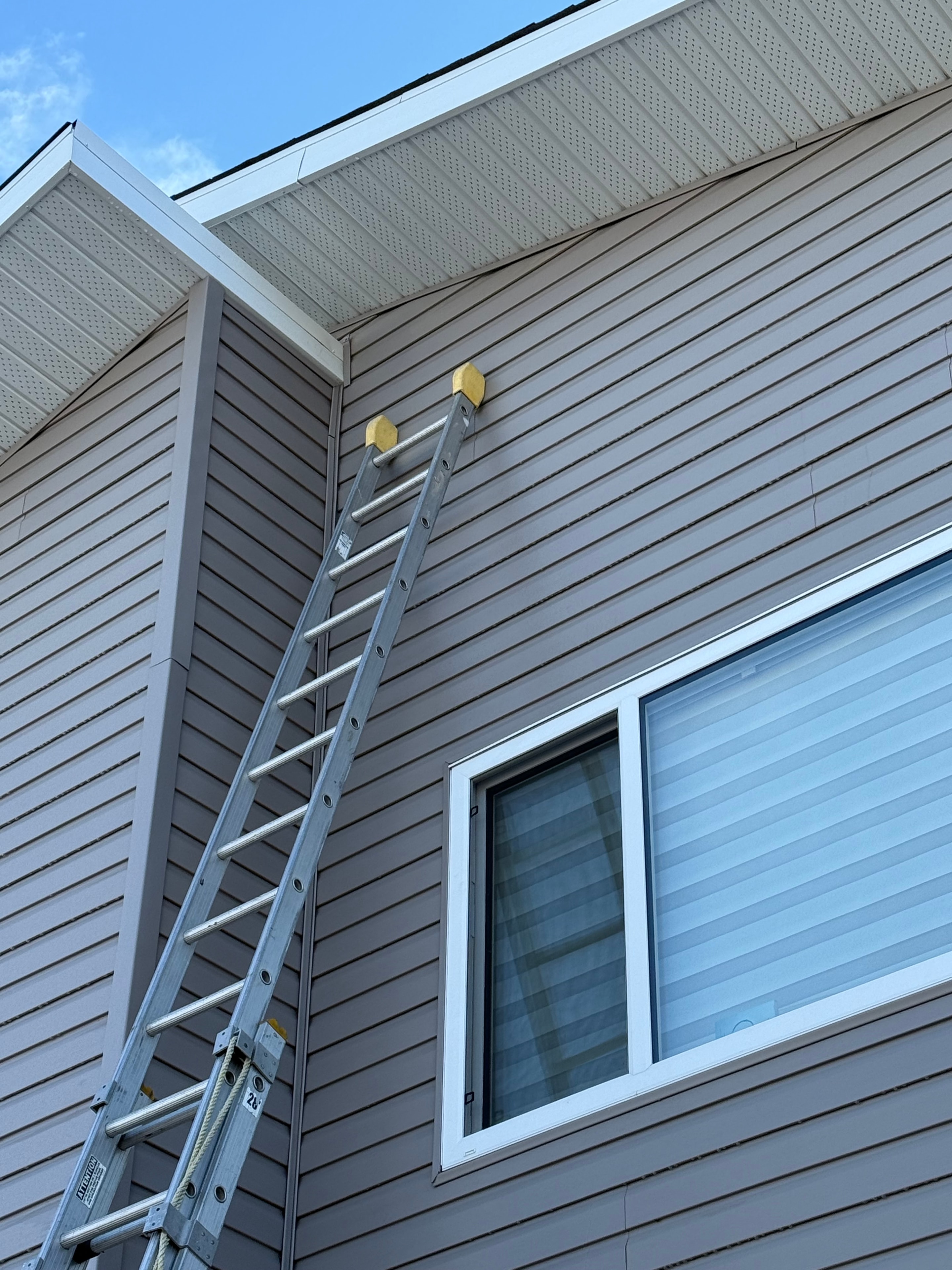 Tan vertical siding with soffit installation Regina